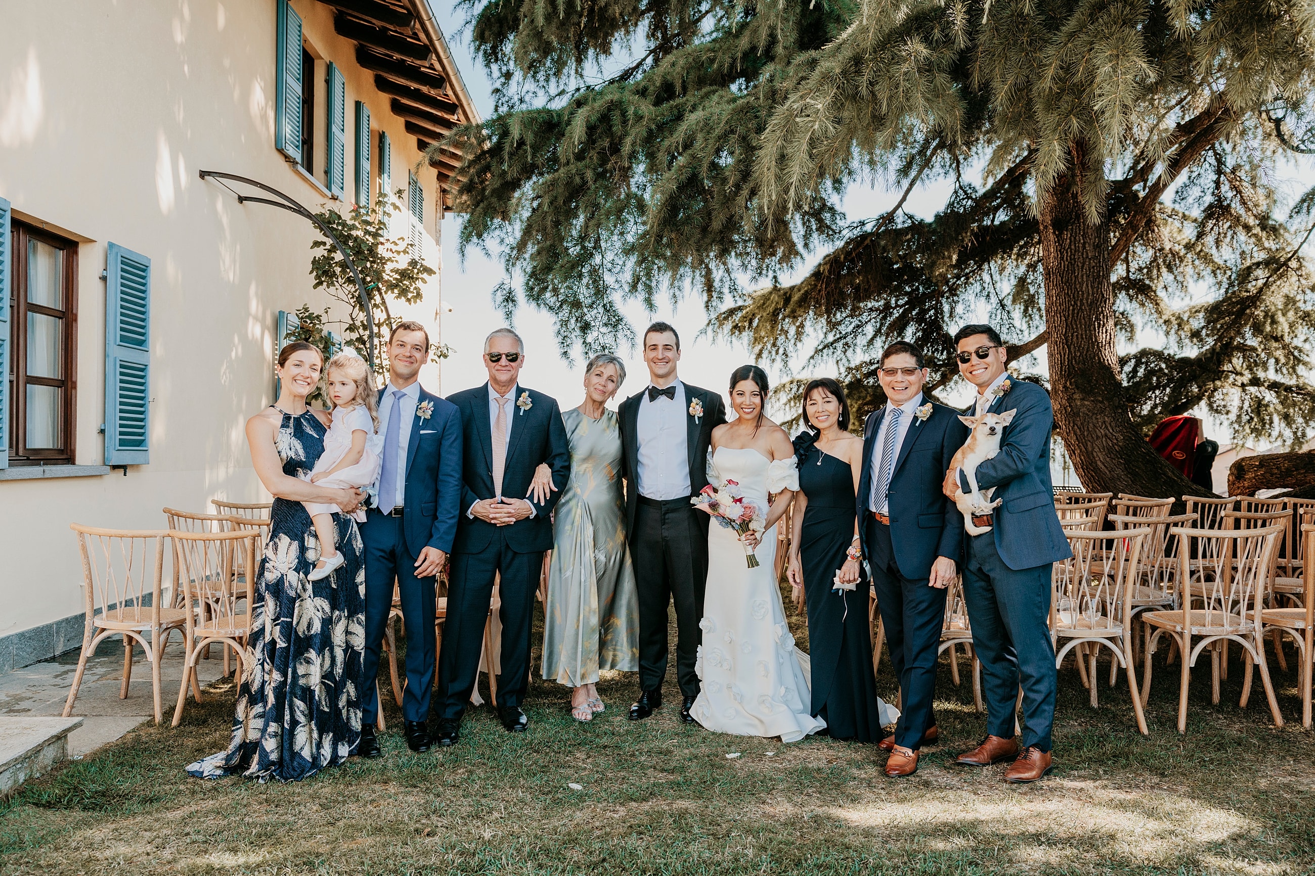Wedding group photo in a scenic outdoor setting.