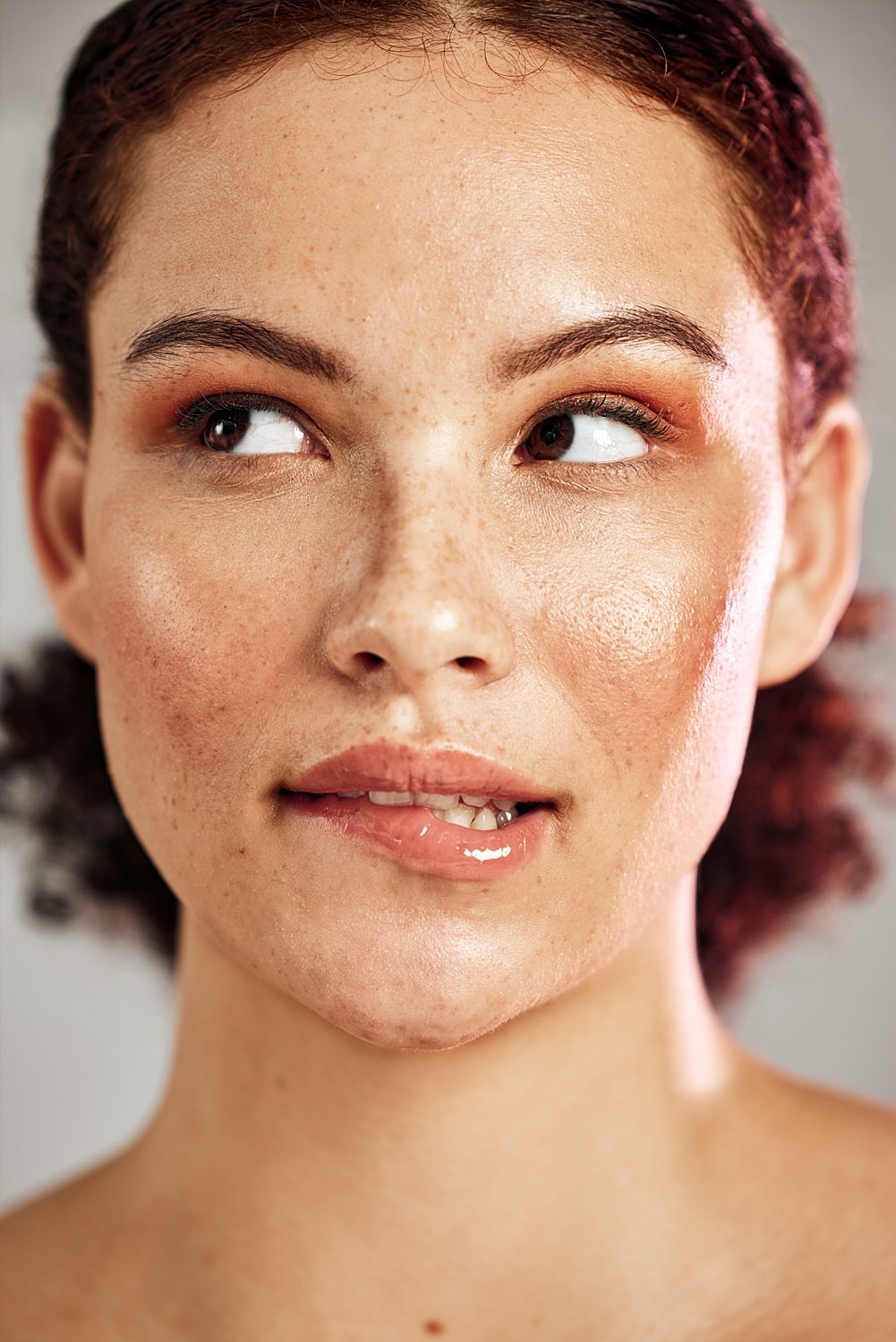 Close-up of a woman with freckles and glowy skin.